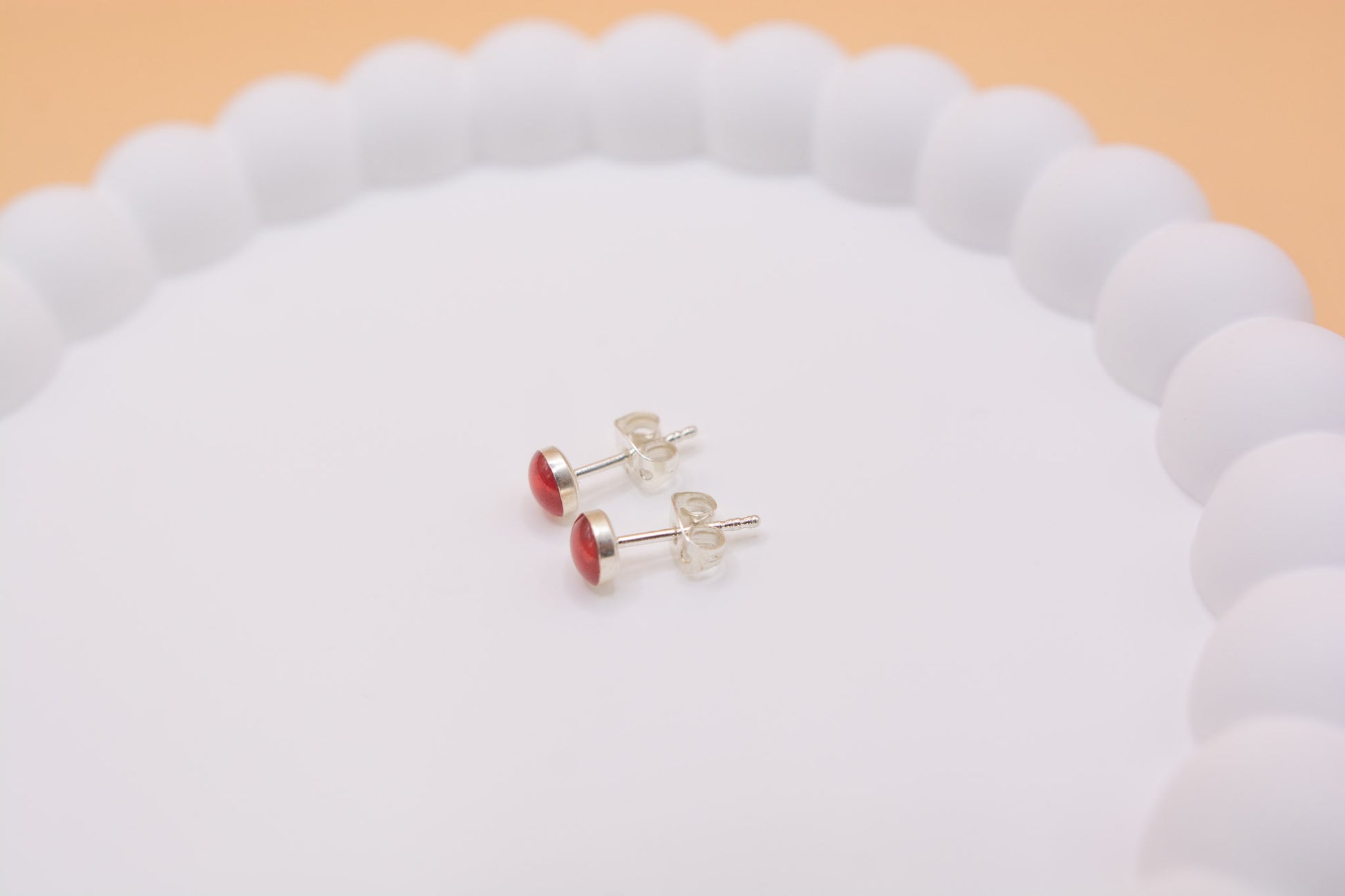 A close-up side view of a pair of keepsake cremation ashes memorial 925 silver stud earrings